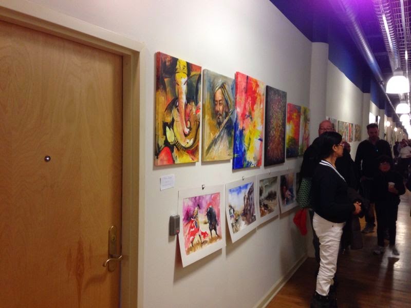 Visitors walking a hallway exhibition of Ganesha, portrait, and abstract paintings